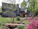 Picturesque backyard featuring a wooden deck, bridge, stone creek bed, lush landscaping, and mature trees at 306 Roebling Ln, Cary, NC 27513