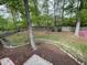 Expansive backyard featuring mature trees, landscaping, a stone creek bed, and a privacy fence at 306 Roebling Ln, Cary, NC 27513