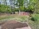 Spacious backyard showcasing mature trees, landscaping, a stone creek bed, and room for outdoor activities at 306 Roebling Ln, Cary, NC 27513