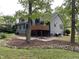 Backyard view with a wooden deck, landscaping, rock features, and mature trees providing shade and privacy at 306 Roebling Ln, Cary, NC 27513