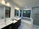 Bright bathroom featuring a double vanity, tub/shower, and open shelving at 306 Roebling Ln, Cary, NC 27513