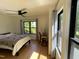 Bedroom with hardwood floors, a ceiling fan, and a desk near the bright window at 306 Roebling Ln, Cary, NC 27513