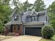 Striking two-story home features gray siding, black trim, brick accents, and a convenient two-car garage at 306 Roebling Ln, Cary, NC 27513