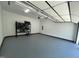 Clean, well-lit garage with epoxy flooring, open garage door, and a storage rack for organization at 306 Roebling Ln, Cary, NC 27513