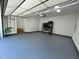 Bright garage with epoxy flooring, featuring a storage rack and plenty of open space for parking at 306 Roebling Ln, Cary, NC 27513