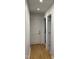Neutral hallway with hardwood floors and white doors, leading to other areas of the home at 306 Roebling Ln, Cary, NC 27513