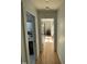 Hallway leading to a bedroom and bathroom, featuring hardwood floors and neutral paint at 306 Roebling Ln, Cary, NC 27513