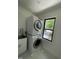 Clean laundry room featuring stacked washer and dryer unit with a view from the window at 306 Roebling Ln, Cary, NC 27513