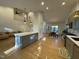 Open-concept kitchen, dining, and living room area with hardwood floors and staircase at 306 Roebling Ln, Cary, NC 27513