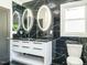 Modern bathroom features dual sinks, led mirrors, sleek black hardware, and tiled walls at 316 Barbour St, Clayton, NC 27520