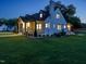 Elegant home at dusk featuring a welcoming porch and carefully maintained landscaping at 316 Barbour St, Clayton, NC 27520
