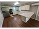 Bright kitchen with white cabinets, stainless steel appliances, and a breakfast bar on hardwood floors at 317 Brewer Rd, Louisburg, NC 27549