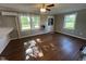 Open living area with hardwood floors, two windows, and a ceiling fan at 317 Brewer Rd, Louisburg, NC 27549
