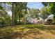 Expansive backyard with lush green lawn, mature trees, and charming home exterior at 3210 Merriman Ave, Raleigh, NC 27607