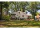 A beautiful white home exterior with a spacious lawn, fence, and mature trees at 3210 Merriman Ave, Raleigh, NC 27607