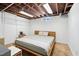 Finished basement with bedroom features exposed ceiling and painted white brick wall at 3210 Merriman Ave, Raleigh, NC 27607