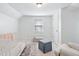 Bright Bedroom features a neutral color palette, a soft carpet, and a cozy armchair for rocking babies at 3210 Merriman Ave, Raleigh, NC 27607