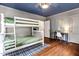 Cozy bedroom with bunk beds, hardwood floors, blue ceiling, and a vintage desk for a playful yet functional space at 3210 Merriman Ave, Raleigh, NC 27607