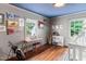 Charming bedroom featuring hardwood floors, a piano, built-in shelves, and an inviting blue ceiling at 3210 Merriman Ave, Raleigh, NC 27607