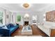 Elegant living room with fireplace, hardwood floors, and white sofas, bathed in natural light at 3210 Merriman Ave, Raleigh, NC 27607