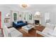 Spacious living room with a fireplace, hardwood floors, and white sofas with natural light at 3210 Merriman Ave, Raleigh, NC 27607