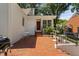 An outdoor patio with brick pavers, table, chairs, and a bright red door at 3210 Merriman Ave, Raleigh, NC 27607
