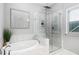 Elegant bathroom featuring a soaking tub and a seamless glass shower with marble tiling and rainfall shower head at 329 Royal Delta Dr, Cary, NC 27519