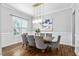Bright dining room with a wooden table, gray chairs, modern lighting, and large windows at 329 Royal Delta Dr, Cary, NC 27519
