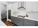 Modern kitchen with white cabinets, gray lower cabinets, stainless steel appliances, and hardwood floors at 329 Royal Delta Dr, Cary, NC 27519