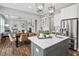 Open kitchen and dining area with an island, stainless steel appliances, and hardwood floors at 329 Royal Delta Dr, Cary, NC 27519