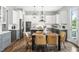 Kitchen and dining area with stainless appliances, gray cabinets, island seating, and a modern dining table at 329 Royal Delta Dr, Cary, NC 27519