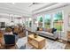 Bright living room featuring a backyard view, with hardwood floors, a couch, and view to the kitchen at 329 Royal Delta Dr, Cary, NC 27519