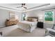 Spacious bedroom features tray ceiling, carpet, two windows, a ceiling fan, and an accent wall with stylish decor at 329 Royal Delta Dr, Cary, NC 27519