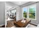Sunlit home office with hardwood floors, a wooden desk, and views of the backyard at 329 Royal Delta Dr, Cary, NC 27519
