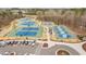 Aerial view of community tennis and pickleball courts with lush landscaping and parking area with several cars in the parking spots at 329 Royal Delta Dr, Cary, NC 27519