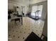 A well-lit kitchen featuring white cabinets and appliances, tiled floors, and a dining area, offering comfort and practicality at 333 Park Ave, Rocky Mount, NC 27801