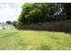 A grassy backyard has a retaining wall and a view of the back of the house at 365 Red Elm Dr, Durham, NC 27713