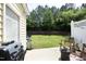 A patio with grill overlooks the backyard with mature trees at 365 Red Elm Dr, Durham, NC 27713
