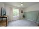 The carpeted bedroom has large window with view to backyard and a ceiling fan at 365 Red Elm Dr, Durham, NC 27713