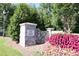 Community entrance sign amid lush greenery and colorful flowers, creating an inviting welcome at 365 Red Elm Dr, Durham, NC 27713