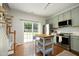 Stylish kitchen with stainless steel appliances, sage cabinetry, and hardwood floors at 365 Red Elm Dr, Durham, NC 27713
