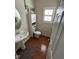 Small bathroom with a pedestal sink, window with blinds, and storage unit above the toilet at 3713 Coach Lantern Ave Ave, Wake Forest, NC 27587