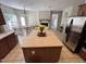 View of the kitchen island, stainless steel refrigerator, and the adjacent dining area with backyard views at 3713 Coach Lantern Ave Ave, Wake Forest, NC 27587
