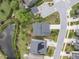 An aerial view of a home with lush landscaping and a driveway, positioned beside a tranquil pond at 437 Henmore Brook Dr Dr, Cary, NC 27519