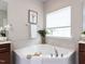 Close up of a bright bathroom featuring a soaking tub and neutral color scheme at 437 Henmore Brook Dr Dr, Cary, NC 27519