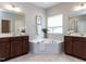 A bright bathroom featuring a soaking tub, double vanity, and neutral color scheme at 437 Henmore Brook Dr Dr, Cary, NC 27519