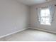 A bright bedroom featuring neutral walls and carpet with a single window at 437 Henmore Brook Dr Dr, Cary, NC 27519