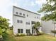 Rear exterior view of a three-story home with multiple windows, a small balcony and staircase leading to the ground at 437 Henmore Brook Dr Dr, Cary, NC 27519
