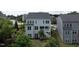 Rear exterior showcasing multiple windows, balcony and stairs on this light-colored three-story home in a landscaped setting at 437 Henmore Brook Dr Dr, Cary, NC 27519