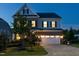 Charming two-story home featuring a brick and siding exterior, well-manicured lawn, and attached two-car garage at dusk at 437 Henmore Brook Dr Dr, Cary, NC 27519